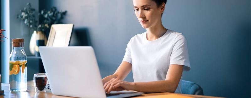 Home-Office in der COVID-19-Pandemie Home-Office: Frau sitzt vor dem Laptop und arbeitet.